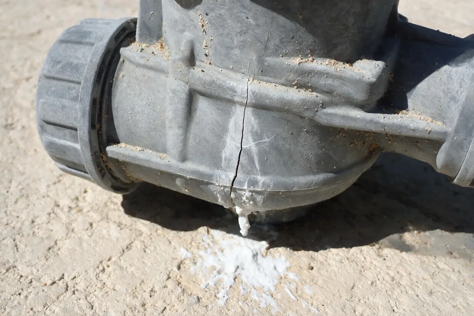 Cracked PVC valve housing on pool plumbing before replacement