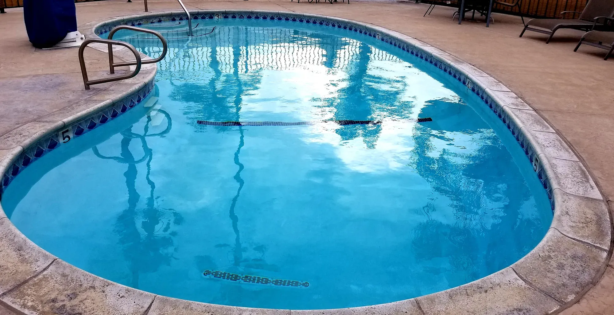 Oval pool with depth markers along the tiled edge