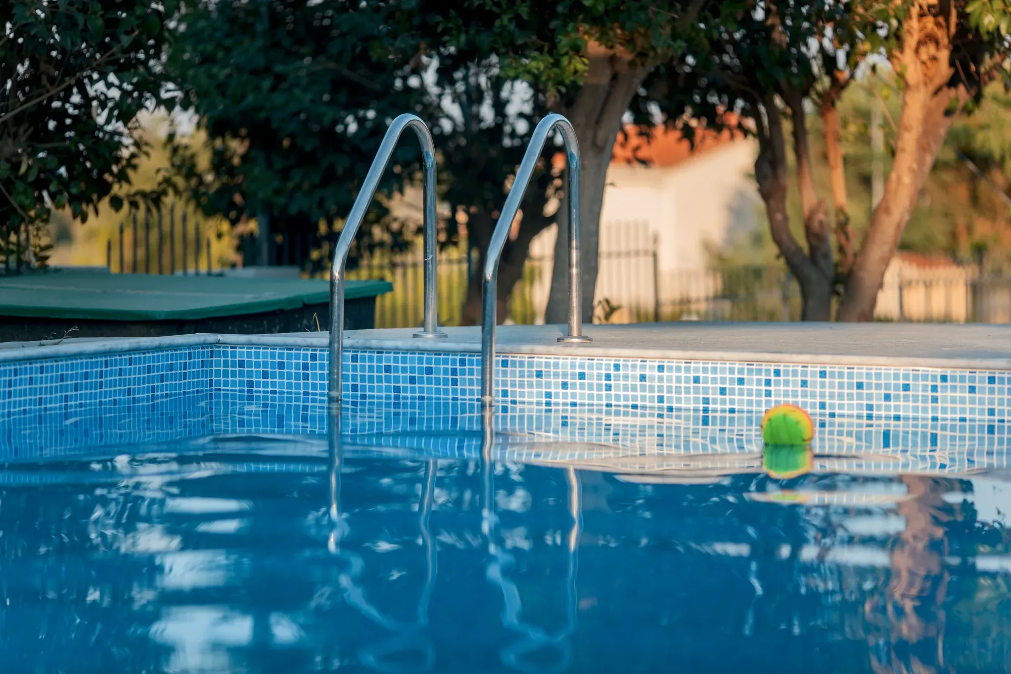 Backyard pool with a ladder and a spa spillover