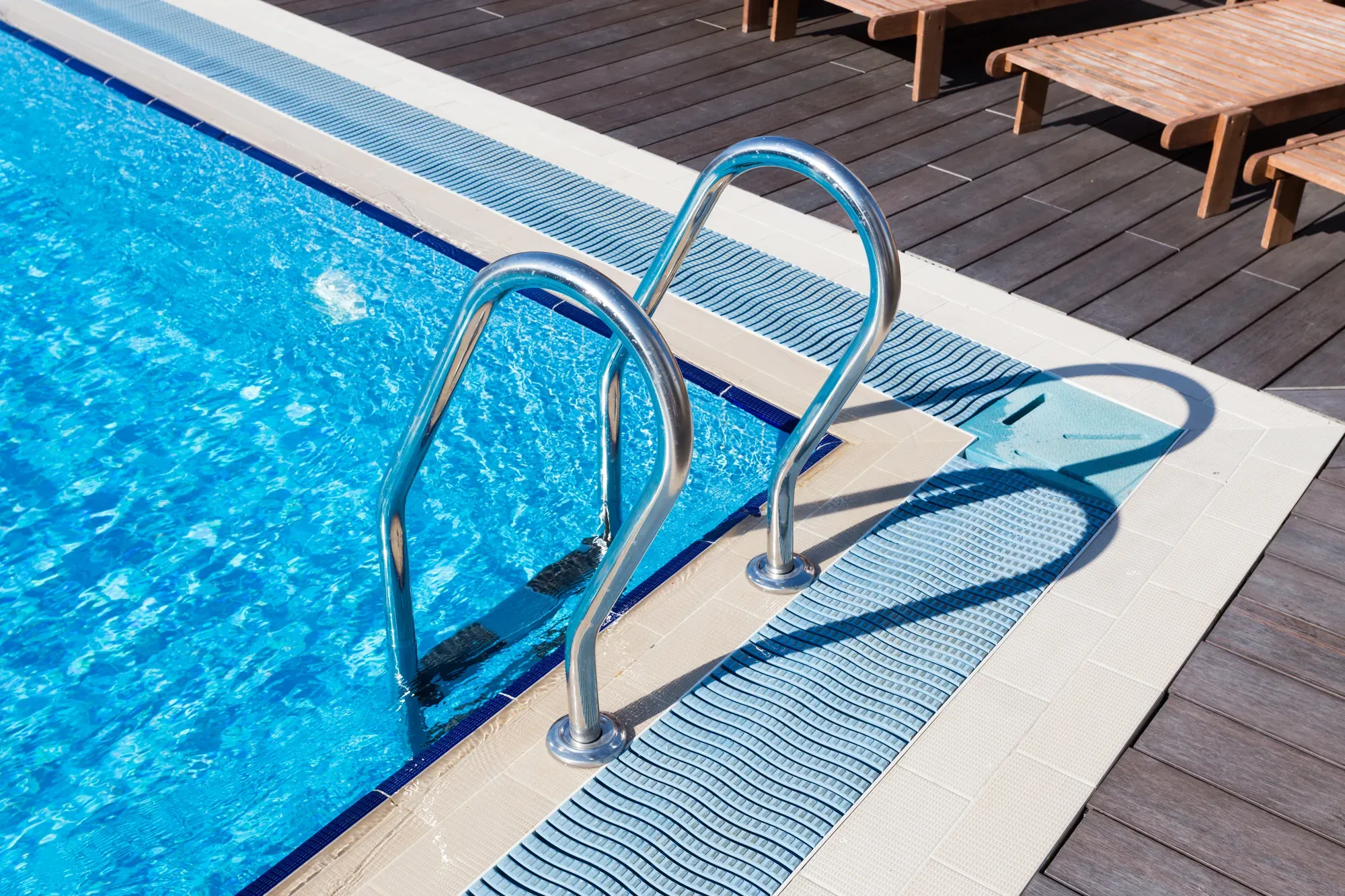 Stainless pool ladder set into a wooden deck