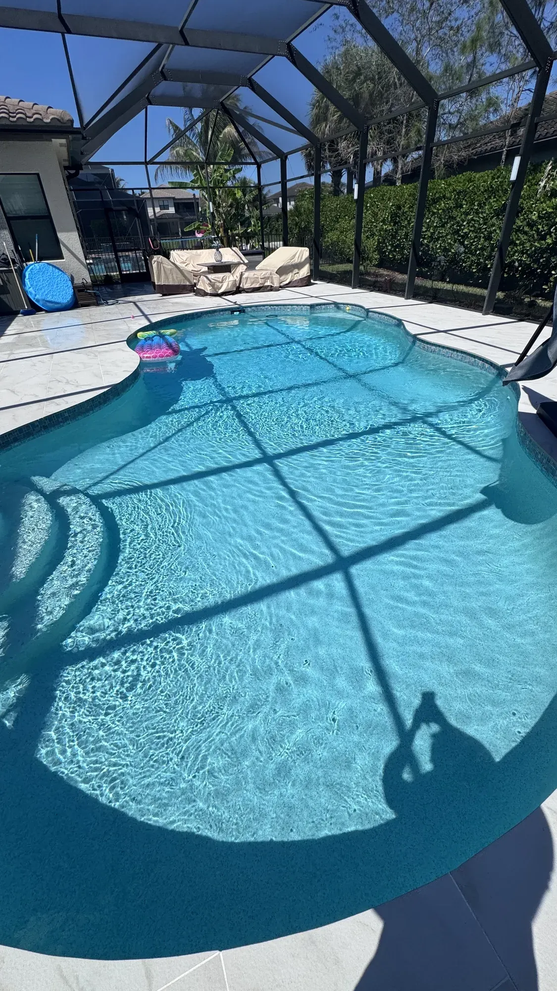 Screened pool with a float and a shaded lounge area