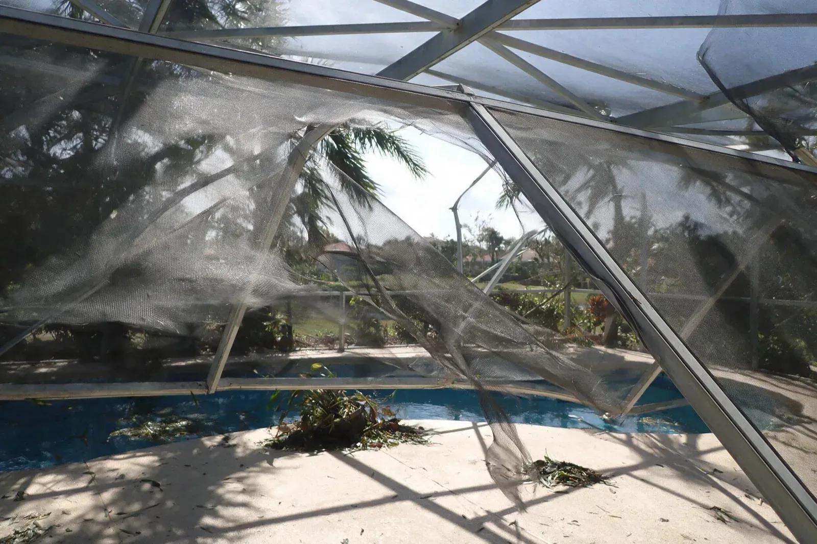 Pool cage screen torn loose after a Cape Coral storm