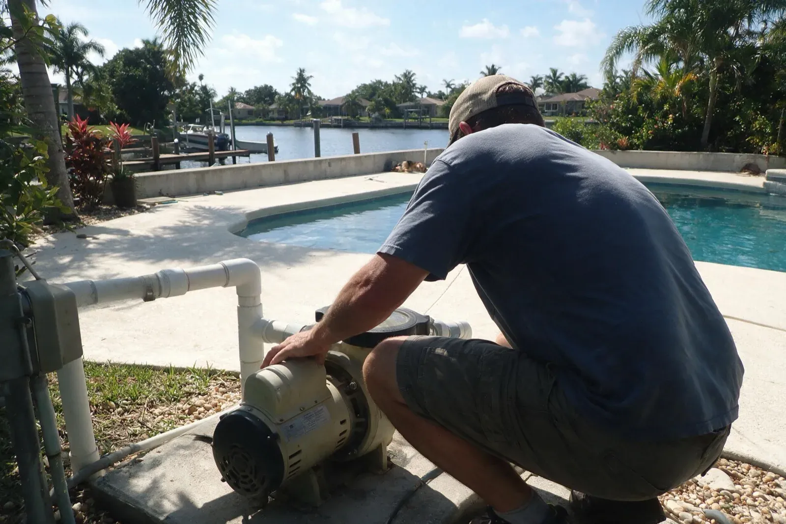 Technician checking a pool pump at a canal-front Cape Coral home